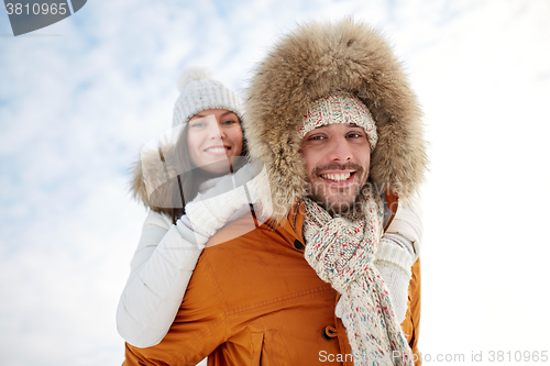 Image of happy couple having fun over winter background