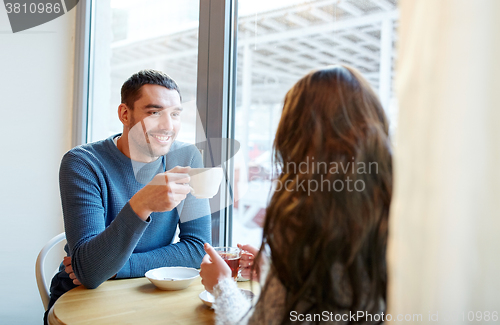 Image of happy couple drinking tea and coffee at cafe