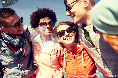 Image of smiling friends in sunglasses laughing on street