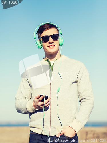 Image of happy young man in headphones with smartphone