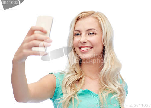 Image of smiling young woman taking selfie with smartphone