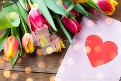 Image of close up of flowers and greeting card with heart