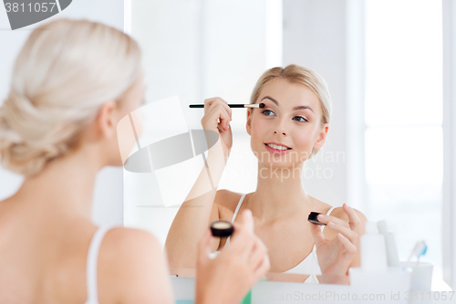 Image of woman with makeup brush and eyeshade at bathroom