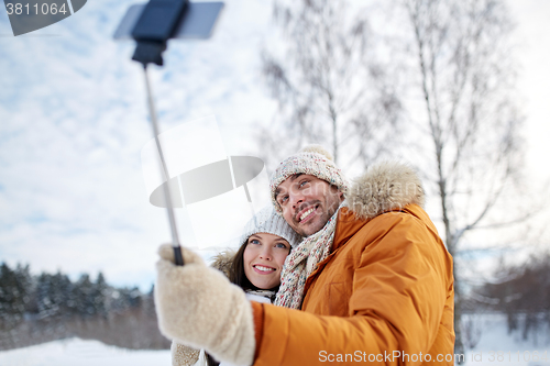 Image of happy couple taking selfie by smartphone in winter