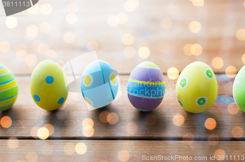 Image of close up of colored easter eggs on wooden surface