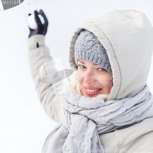 Image of Girl snowball fighting in winter time.