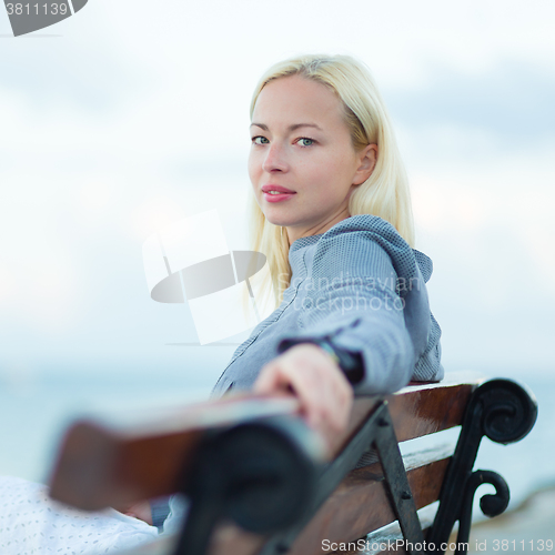 Image of Lady sitting on a bench outdoors