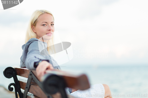 Image of Lady sitting on a bench outdoors