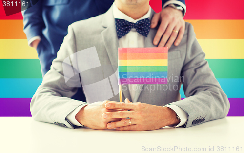 Image of close up of male gay couple holding rainbow flag