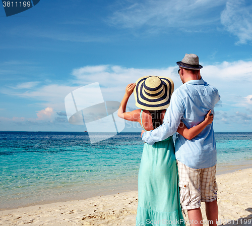 Image of Vacation Couple walking on tropical beach Maldives.