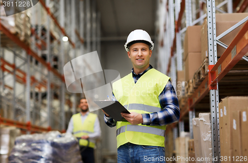 Image of man with clipboard in safety vest at warehouse