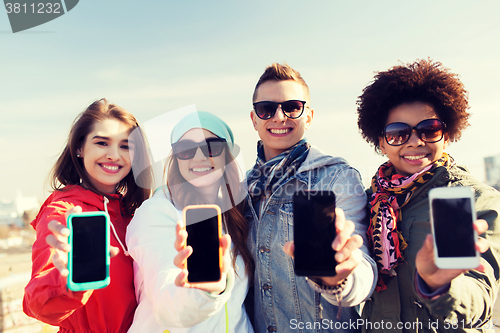 Image of smiling friends showing blank smartphone screens