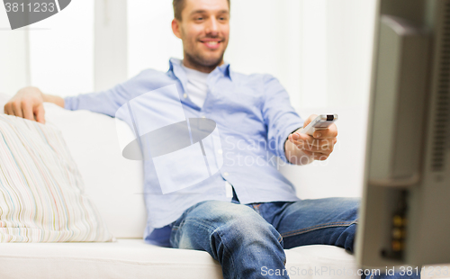 Image of close up of man with tv remote control at home