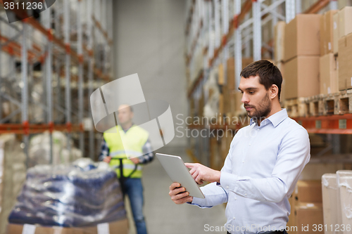 Image of businessman with tablet pc at warehouse