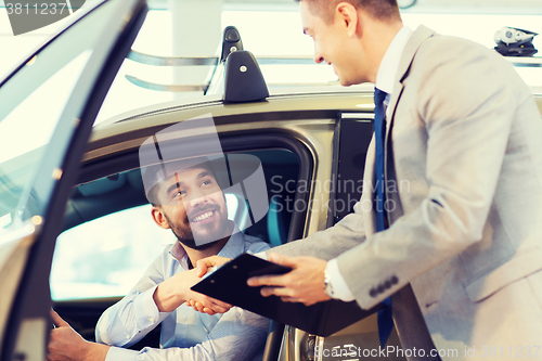 Image of happy man with car dealer in auto show or salon