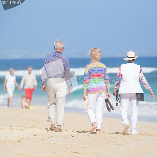 Image of Active seniors enjoying beach walk.