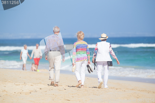 Image of Active seniors enjoying beach walk.