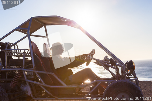 Image of Woman driving quadbike in sunset.