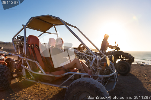 Image of Woman driving quadbike in sunset.