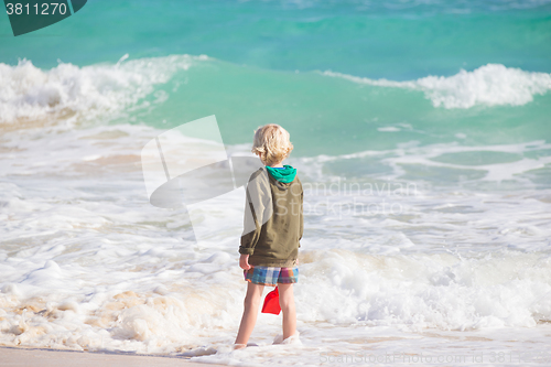 Image of Boy playing with toys on beach.