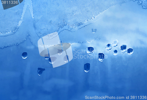 Image of Water drops, ice pattern and sunlight on window glass