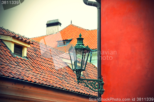 Image of Traditional street lamp and the tiled roofs of Prague
