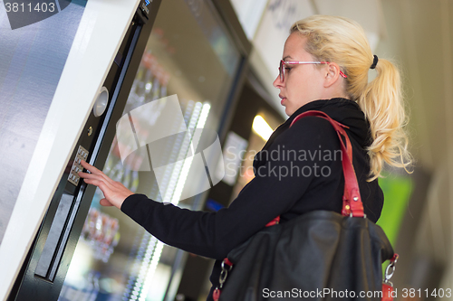 Image of Lady using  a modern vending machine