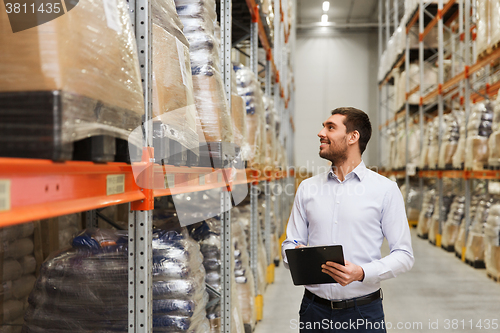 Image of businessman with clipboard at warehouse
