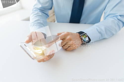 Image of close up of hands with smart phone and watch