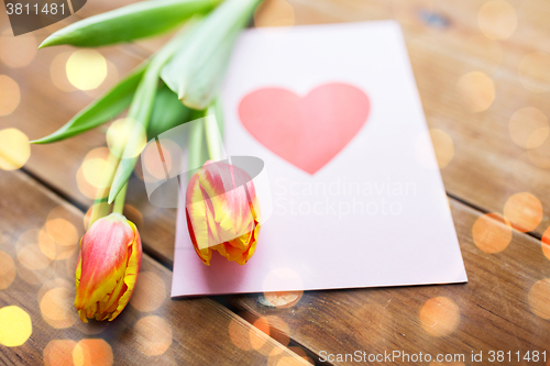 Image of close up of flowers and greeting card with heart