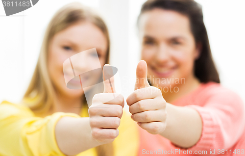 Image of  happy teenage girls showing thumbs up