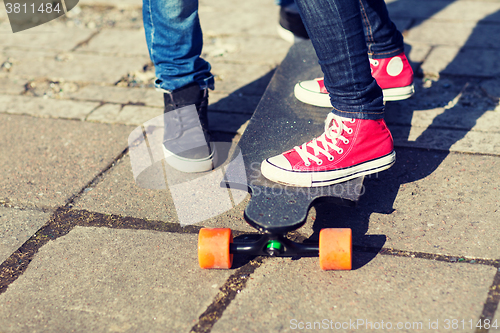 Image of close up of couple with longboard on street