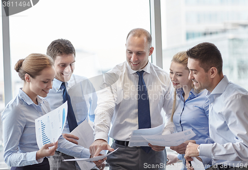 Image of business people with papers talking in office