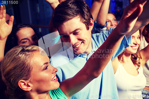 Image of smiling friends at concert in club