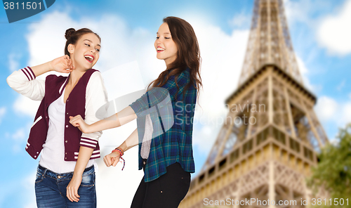 Image of happy teenage girls dancing over eiffel tower