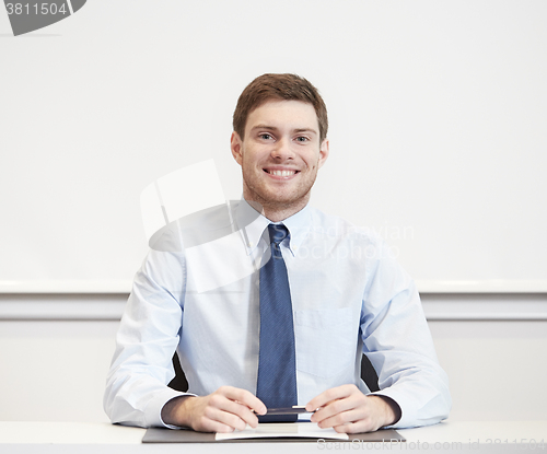 Image of smiling businessman sitting in office