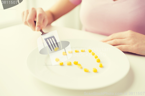 Image of close up of woman with fork eating corn