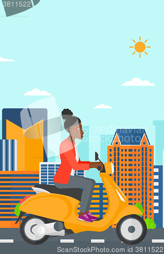 Image of Woman riding scooter.