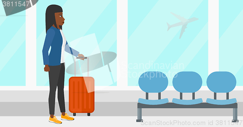 Image of Woman at airport with suitcase.