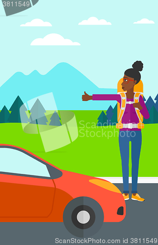 Image of Young woman hitchhiking.