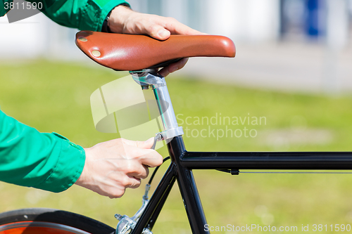 Image of close up of man adjusting fixed gear bike saddle