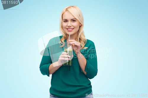 Image of smiling woman drinking vegetable juice or smoothie