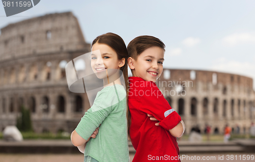Image of happy boy and girl standing over coliseum in rome