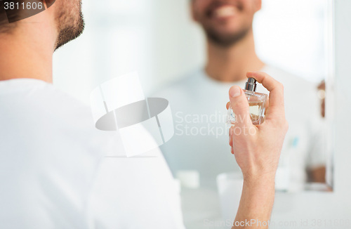 Image of close up of man perfuming with perfume at bathroom