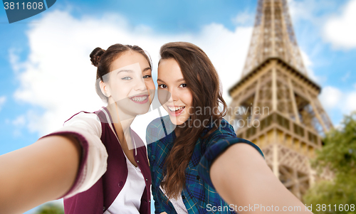 Image of teenage girls taking selfie over eiffel tower