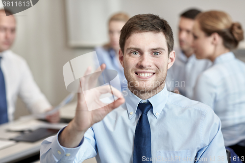 Image of group of smiling businesspeople meeting in office