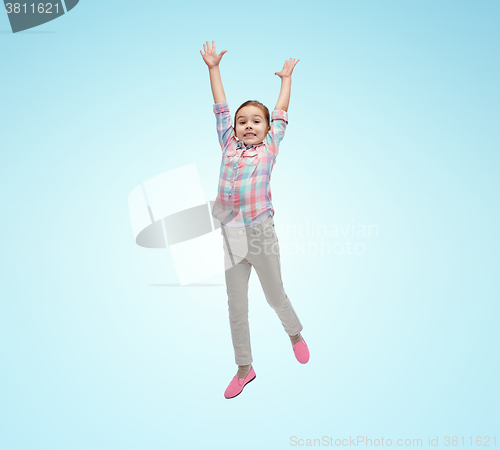 Image of happy little girl jumping in air over blue