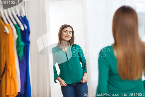 Image of happy woman posing at mirror in home wardrobe