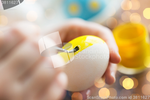 Image of close up of woman hands coloring easter eggs