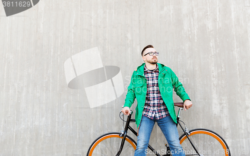 Image of happy young hipster man with fixed gear bike